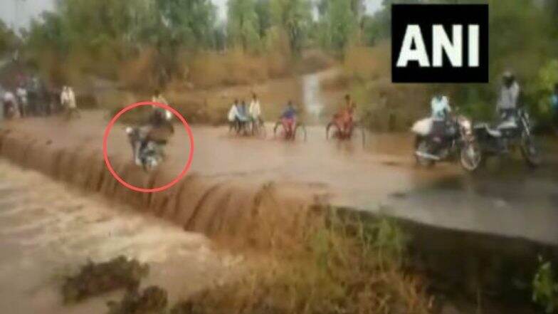 मध्य प्रदेश: वाहत्या पाण्याच्या ओघात बाईकस्वार बुडाला, नागरिकांनी दक्षता दाखवून तरुणाचा वाचवला जीव (Video) मध्य प्रदेश: वाहत्या पाण्याच्या ओघात बाईकस्वार बुडाला, नागरिकांनी दक्षता दाखवून तरुणाचा वाचवला जीव (Video)